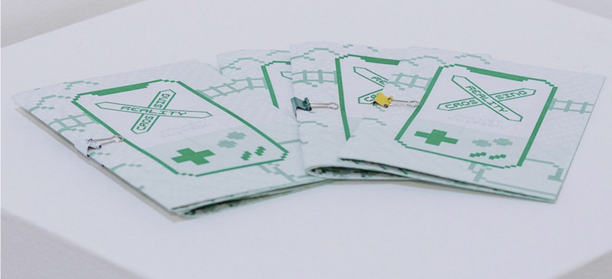 Detail of the takeaway risograph zines on a plinth, featuring a pull-out version of the augmented reality trigger map.